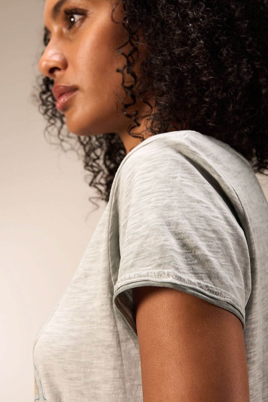 Femme portant un t-shirt imprimé artistique, mettant en valeur la coupe confortable et le tissu doux.