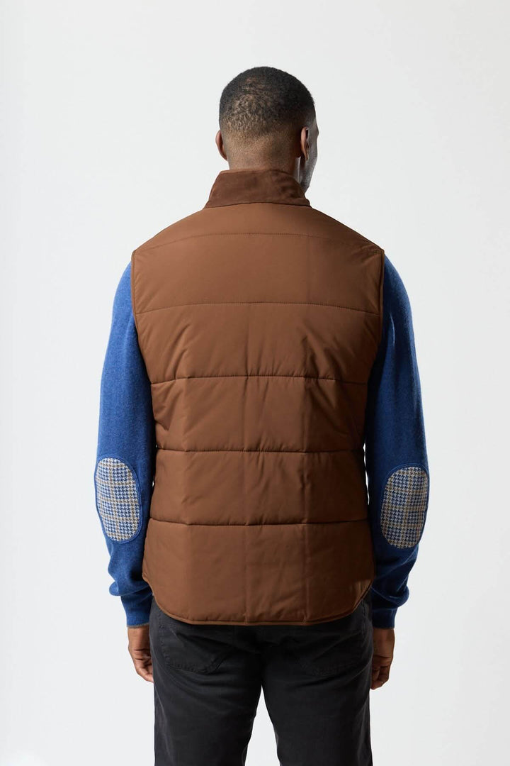 Homme portant une veste sans manches en simili suède marron de Waterville, vue arrière, élégance moderne et confort matelassé.