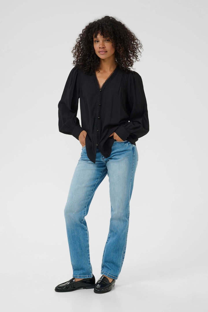 Alt Tag: Femme portant la Chemise Mirabel à col V et détails de dentelle avec un jean, style chic et décontracté.