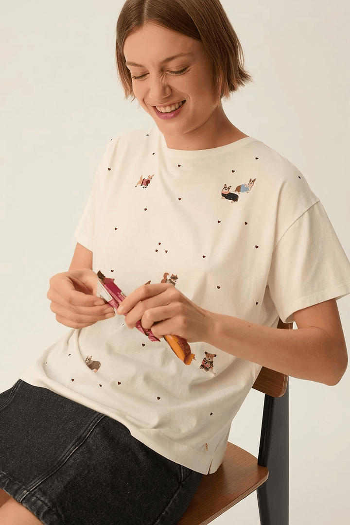 T-shirt Fanelie ample imprimé chiens, femme assise, motifs chiens et mini cœurs, coupe ample, col rond classique, style décontracté.