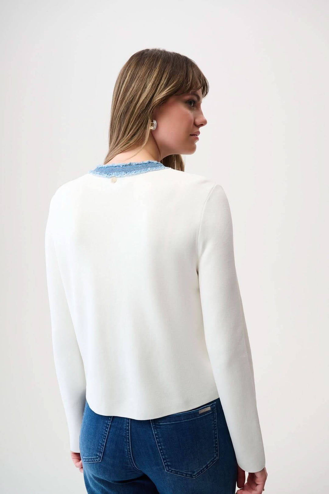 Cardigan élégant avec détails denim effilochés et boutons métalliques, vu de dos, porté par un mannequin avec jeans.