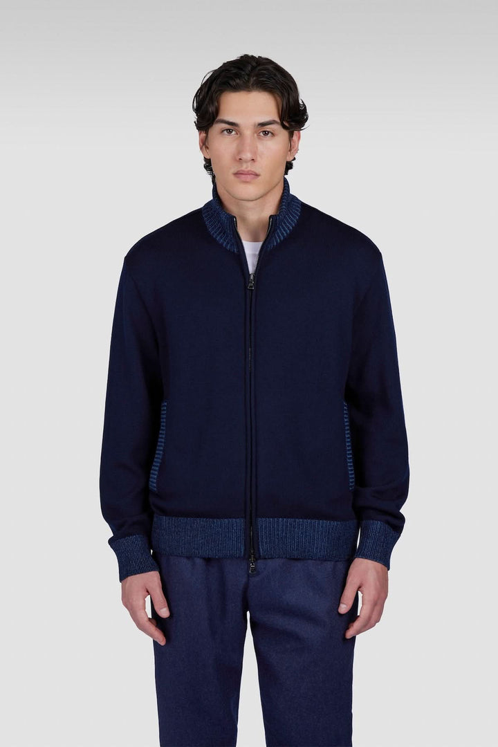 Cardigan à fermeture éclair bleu marine avec col structuré et détails contrastés, porté par un homme.