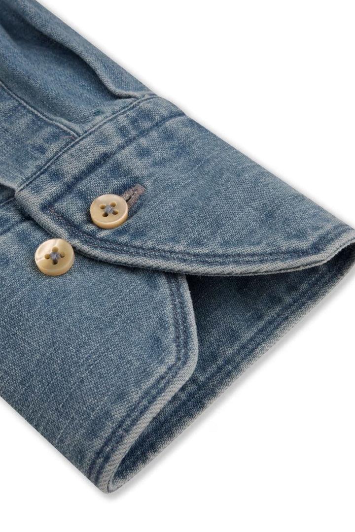 Chemise en denim poches poitrine et boutons nacrés, gros plan sur boutons en nacre et couture délicate en coton.