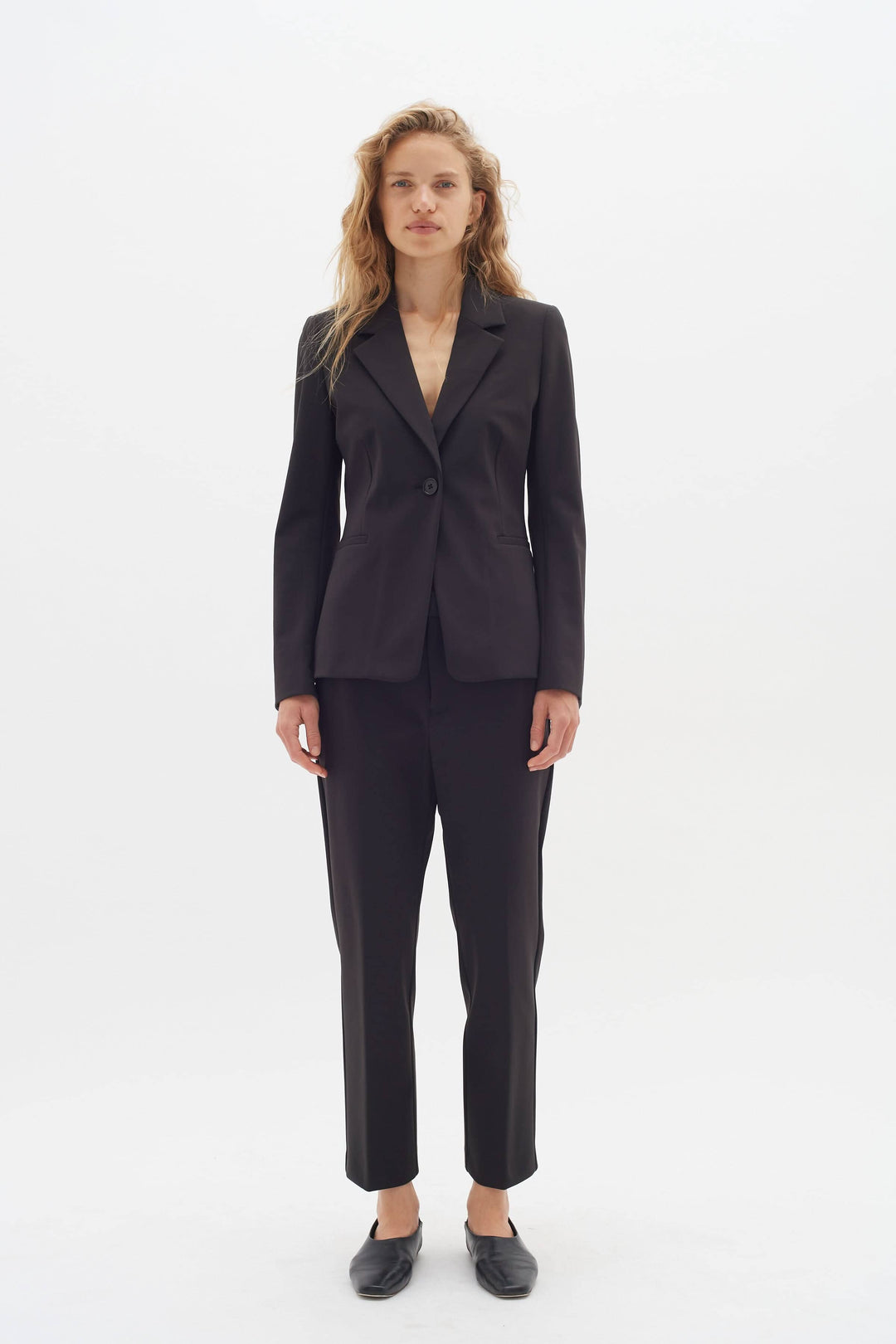 Veston de voyage Zeal en tissu souple, coupe slim, porté avec un pantalon assorti pour un look chic et confortable.