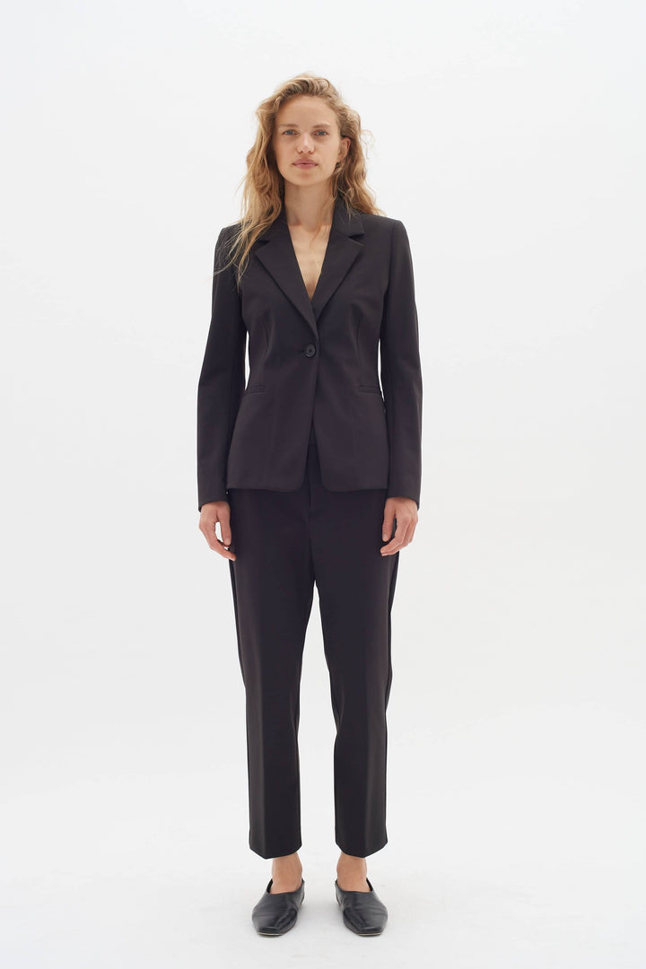 Veston de voyage Zeal en tissu souple, coupe slim, porté avec un pantalon assorti pour un look chic et confortable.