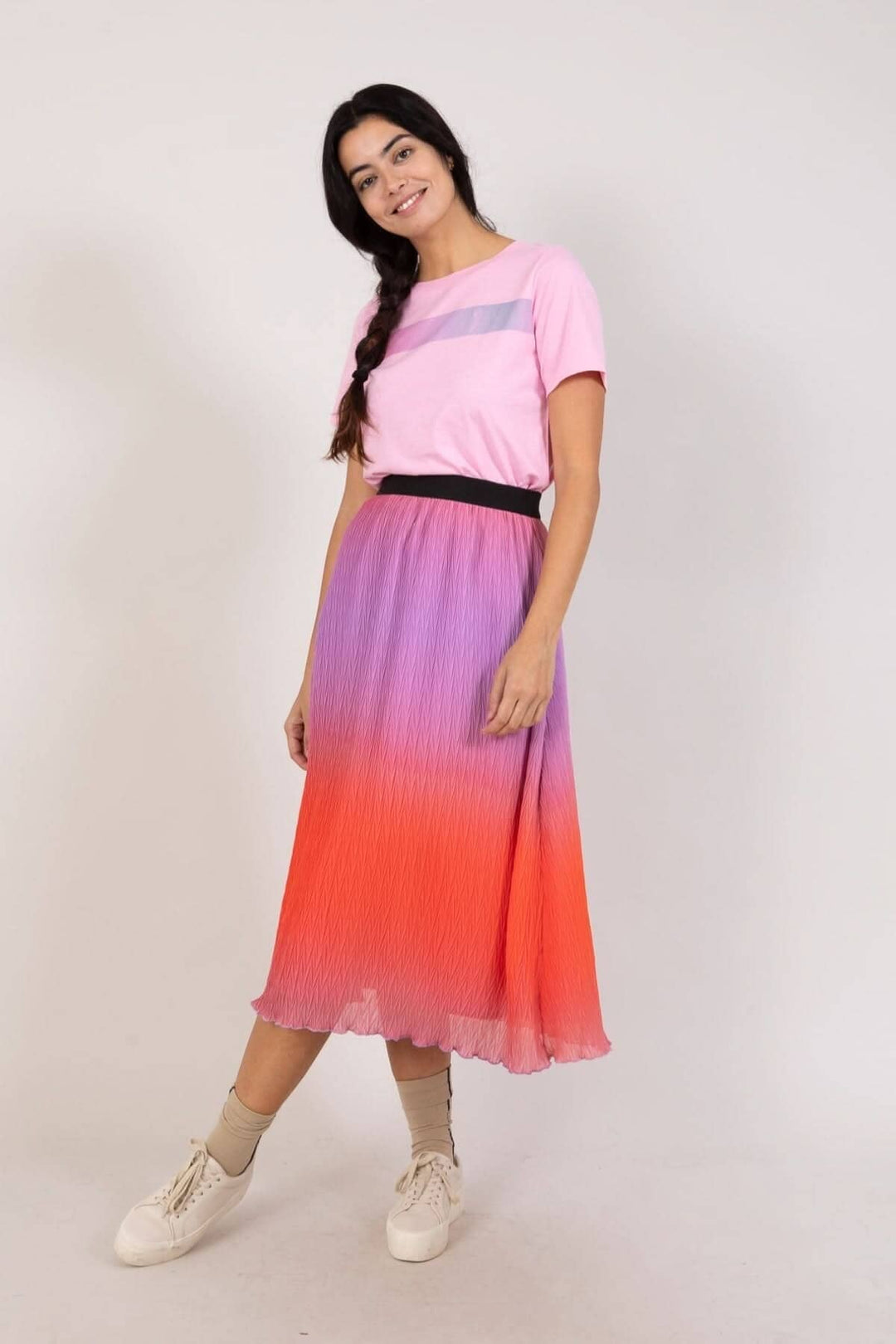 Jupe plissée dégradé en violet et orange, t-shirt rose, look moderne et féminin, bande élastique à la taille.