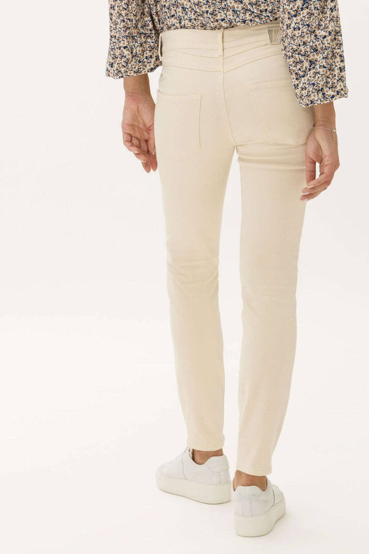 Pantalon skinny ANA pour femmes, coupe super-slim, porté avec un top à fleurs et des baskets blanches.