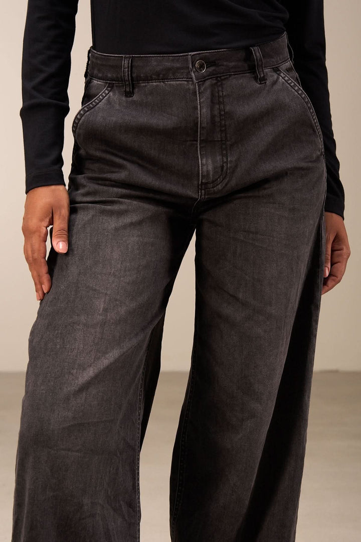 Jean coupe large noir à taille mi-haute et jambes amples, parfait pour un look décontracté ou habillé.