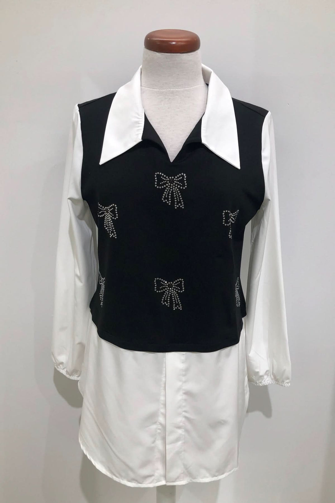 Tunique bicolore élégante avec nœuds strass, col chemise blanc et manches bouffantes, parfaite pour un look de bureau stylé.