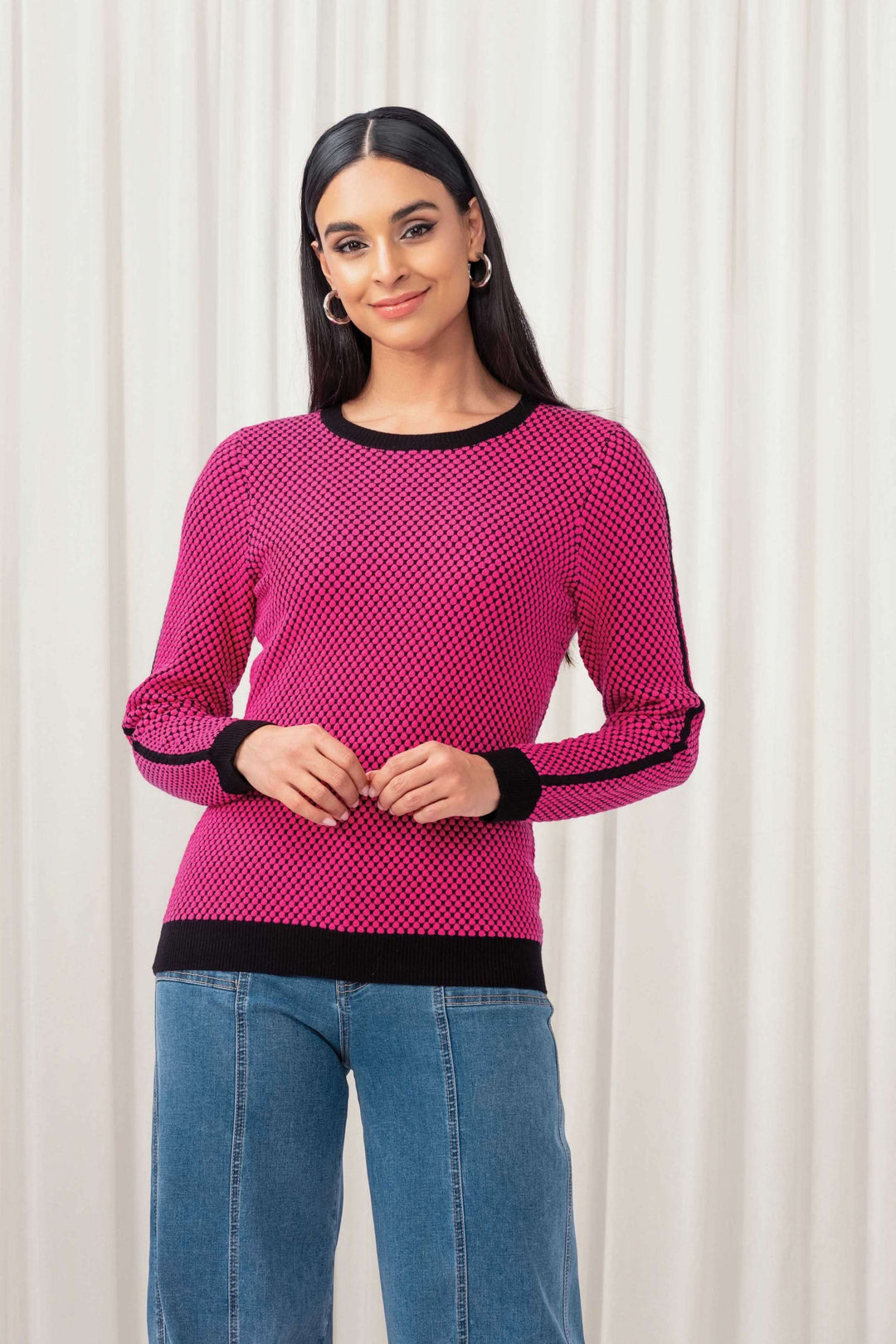 Pull tricot à manches longues rose avec motif graphique, coupe ajustée, porté avec un jean.