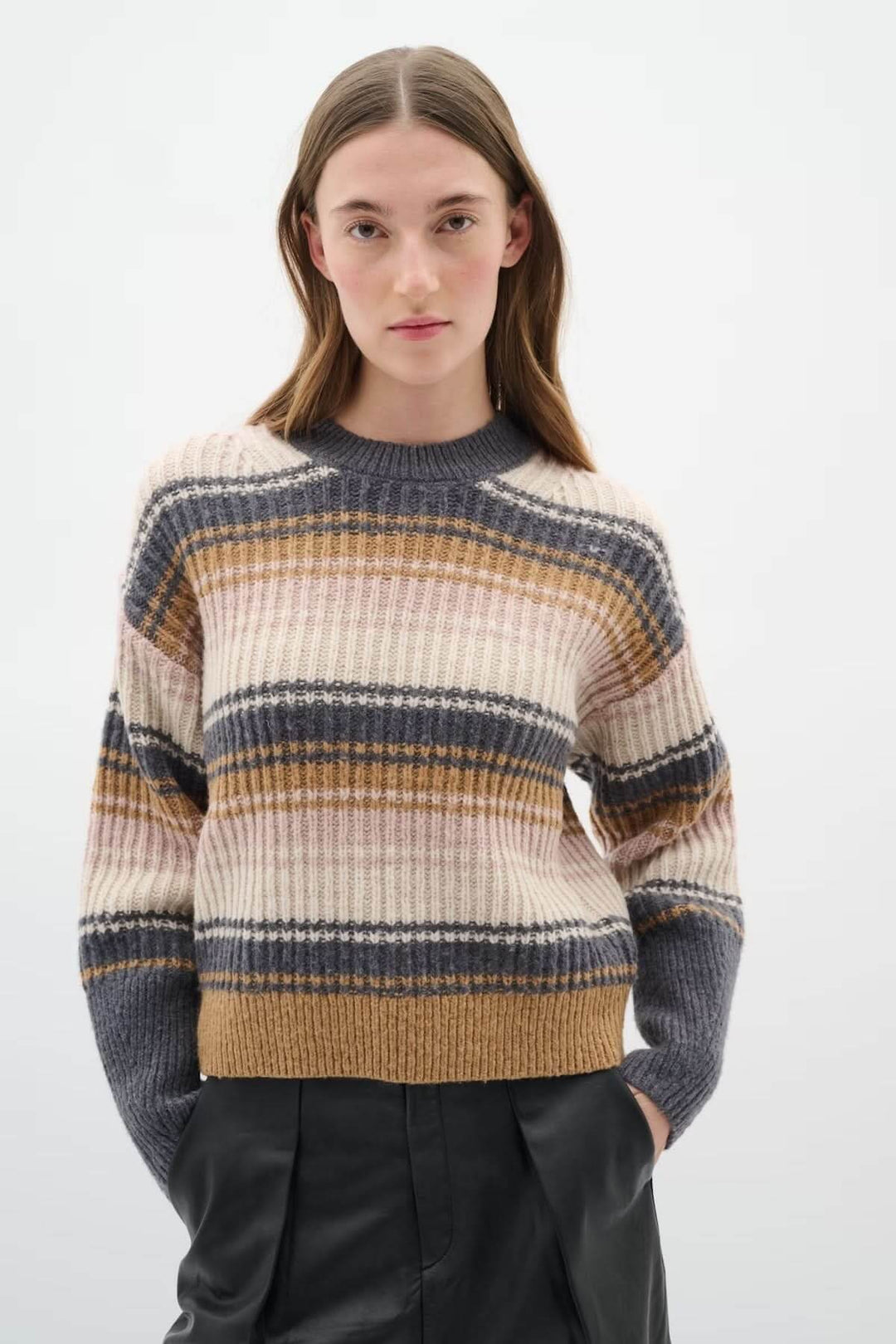 Chandail rayé en maille côtelée multicolore porté par une femme, idéal pour un style moderne et confortable.