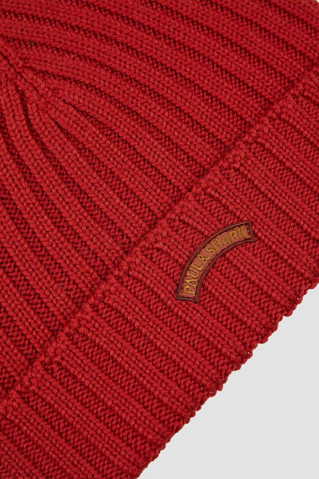 Tuque en maille côtelée rouge avec revers doublé et écusson tissé pour un style urbain et confortable.