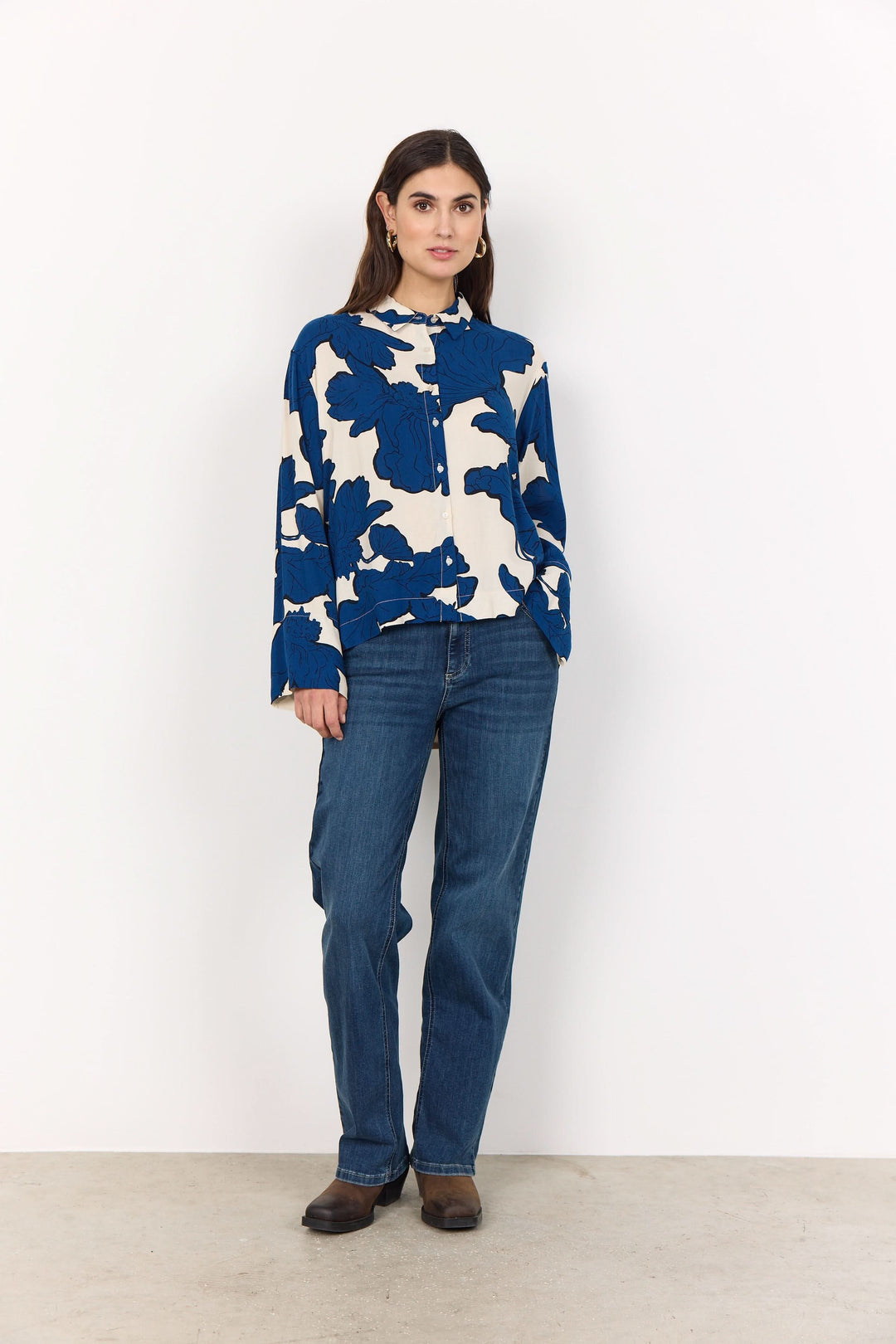 Chemise floral oversize bleue et blanche portée avec un jean taille haute pour un style chic.