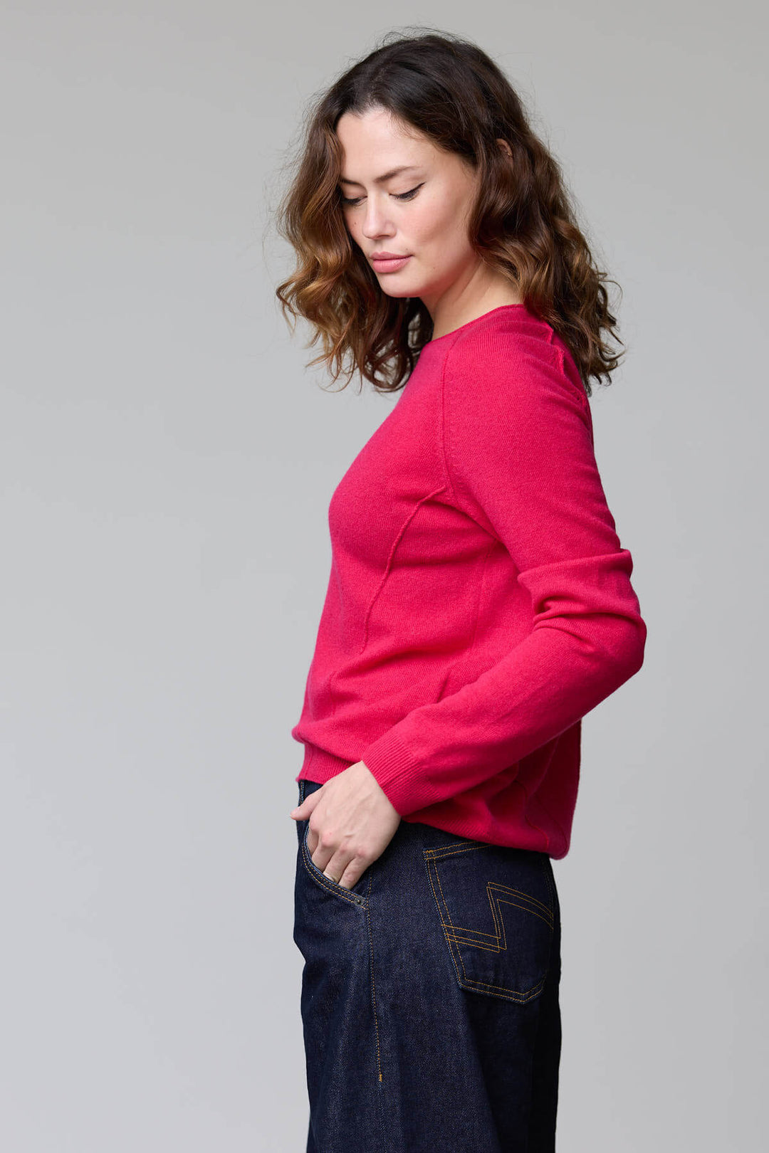 Femme portant un chandail à col rond rouge, coupe classique et maille fine, élégant et confortable, style décontracté et épuré.