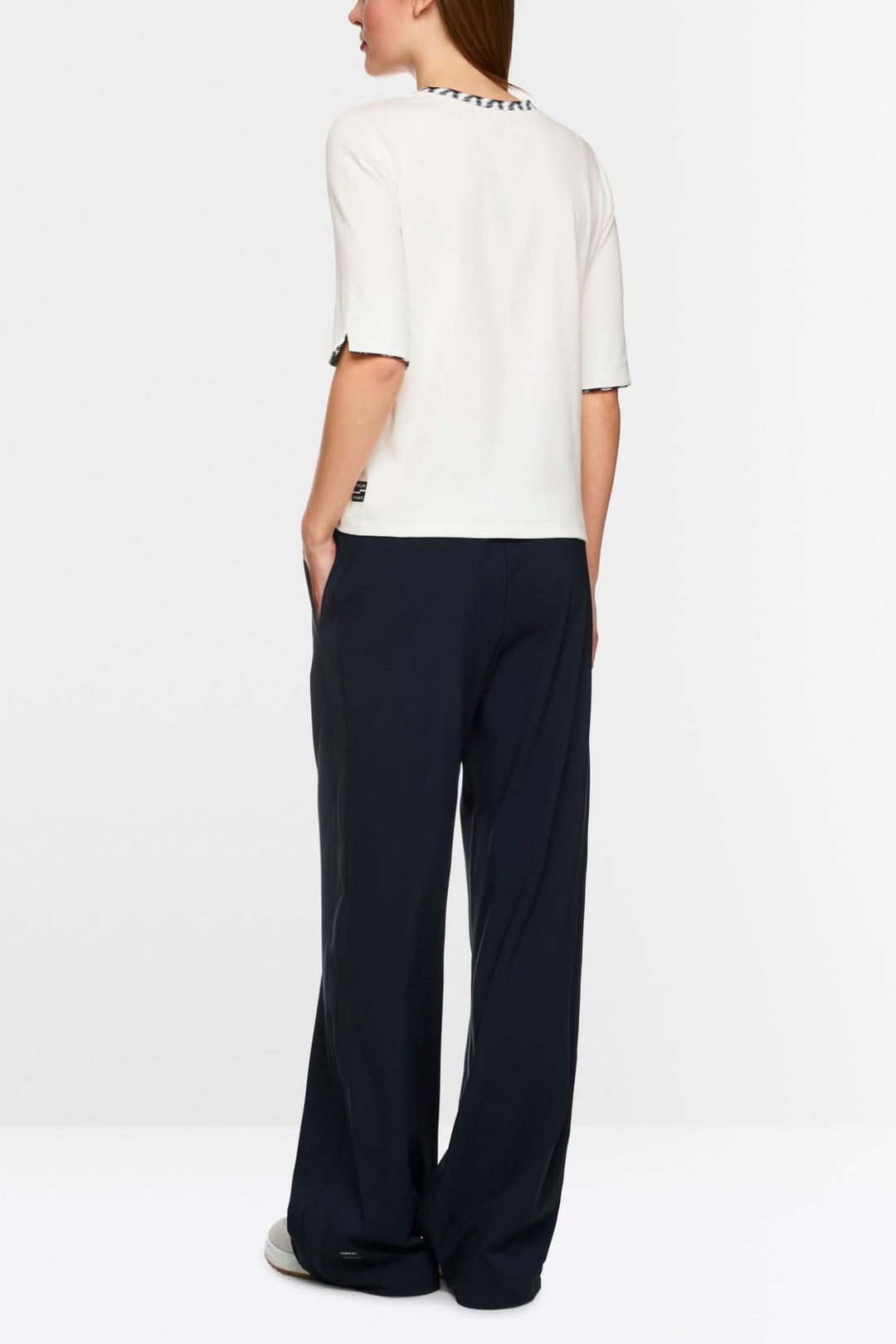 T-shirt en jersey avec encolure ronde et manches mi-longues, porté avec un pantalon ample.