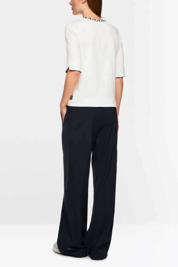 T-shirt en jersey avec encolure ronde et manches mi-longues, porté avec un pantalon ample.