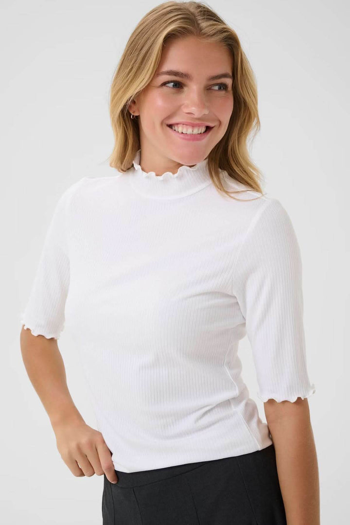 Femme portant le T-shirt Ribba avec col montant festonné, manches mi-longues et maille côtelée, idéal pour un style décontracté chic.