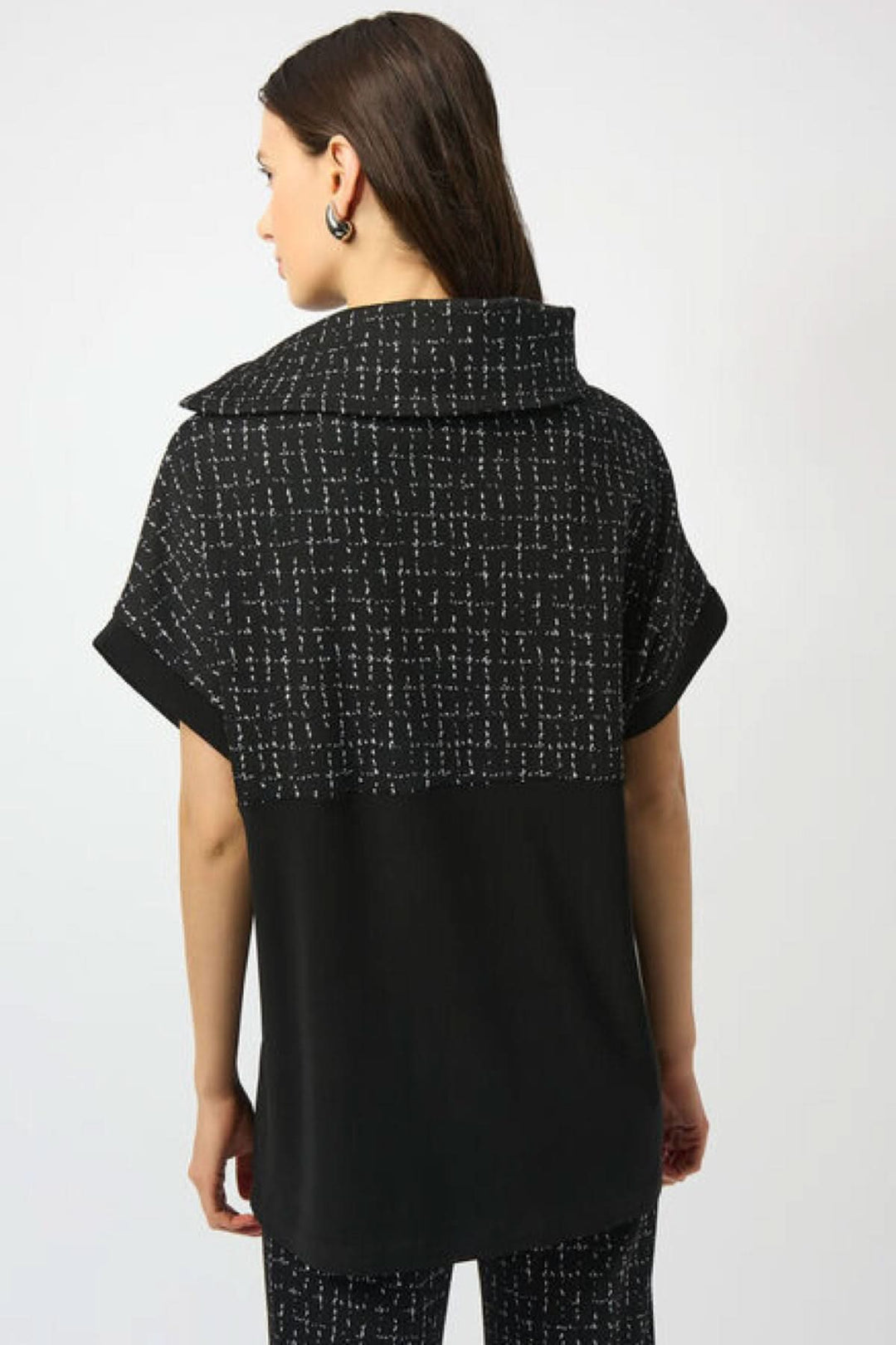 Haut noir à manches courtes avec motif graphique blanc et col asymétrique, vue arrière.