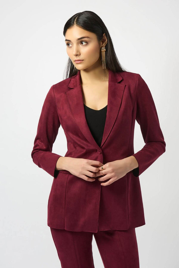 Veston long suédé bordeaux avec une coupe ajustée, porté sur un haut noir, look sophistiqué.