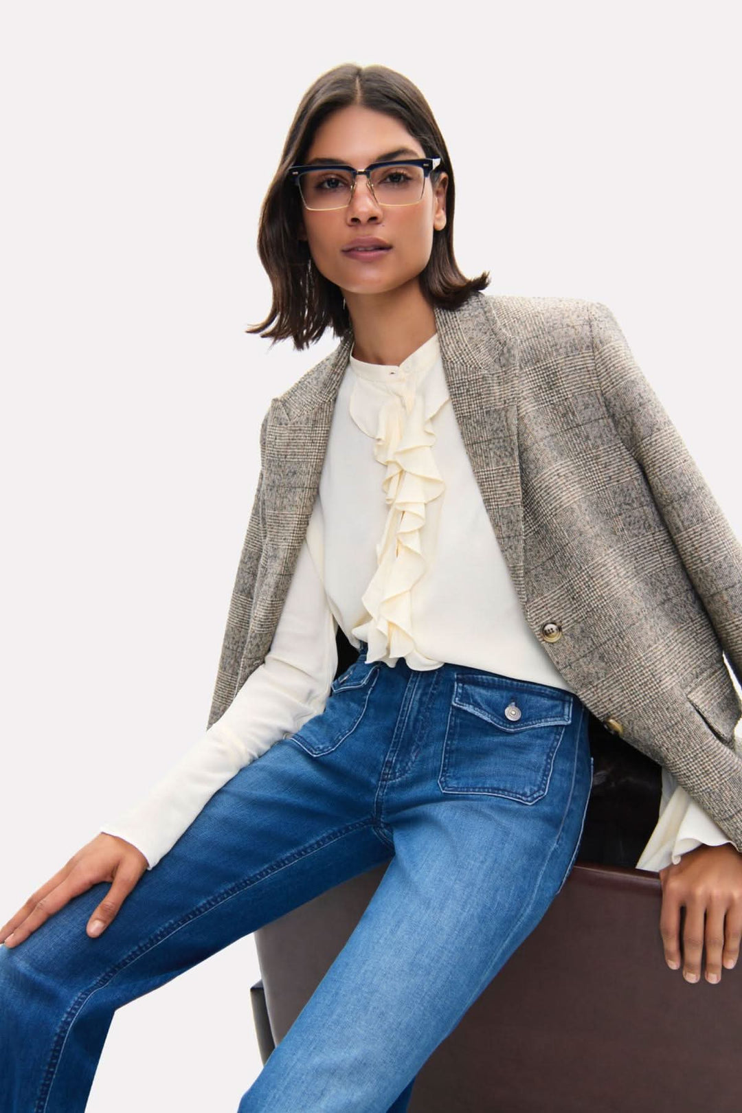 Femme portant le jean Aimee patched pocket avec un blazer chic et une blouse à volants.