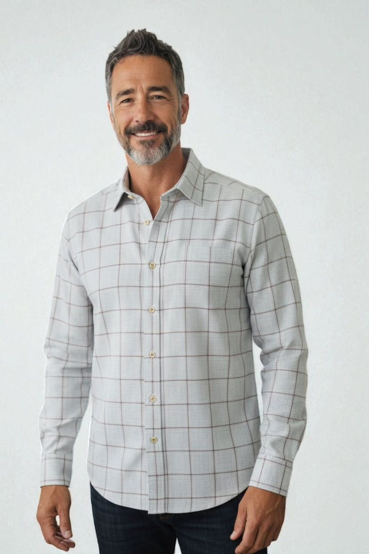 Homme portant une chemise en flanelle grise à carreaux avec col cutaway et boutons en nacre, présentant un look élégant et décontracté.