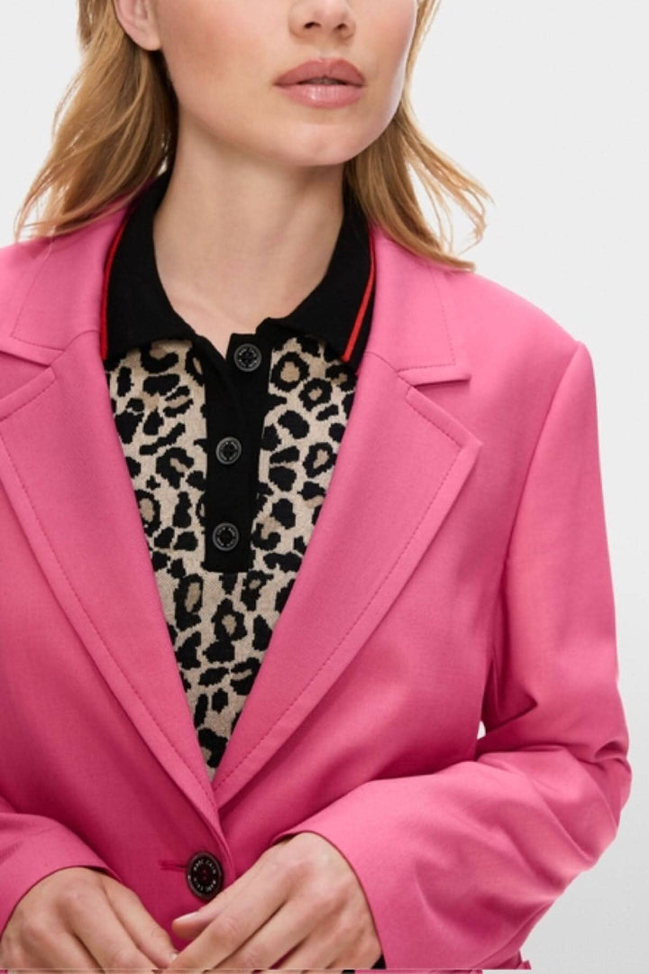 Veston à coupe étroite rose avec revers classique et chemise à motif léopard, modèle féminin.