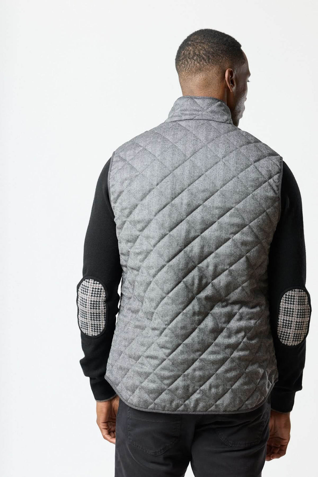 Homme portant une veste sans manches matelassée en laine à motif chevrons vue de dos.