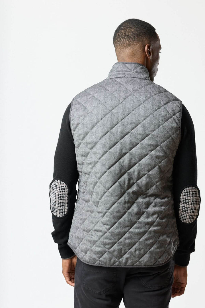 Homme portant une veste sans manches matelassée en laine à motif chevrons vue de dos.