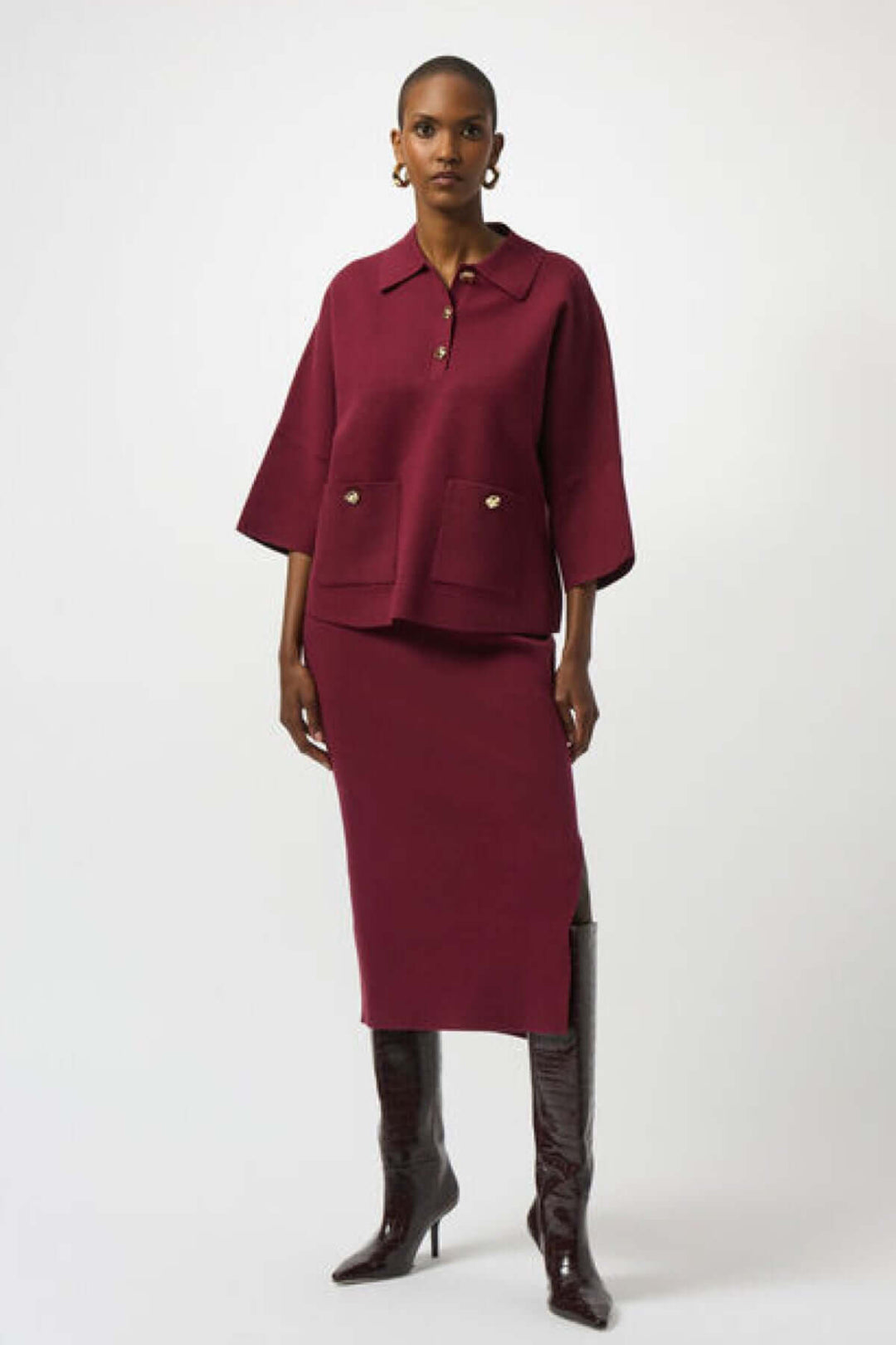 Femme portant une jupe crayon en tricot bordeaux et un haut assorti, style chic et professionnel.