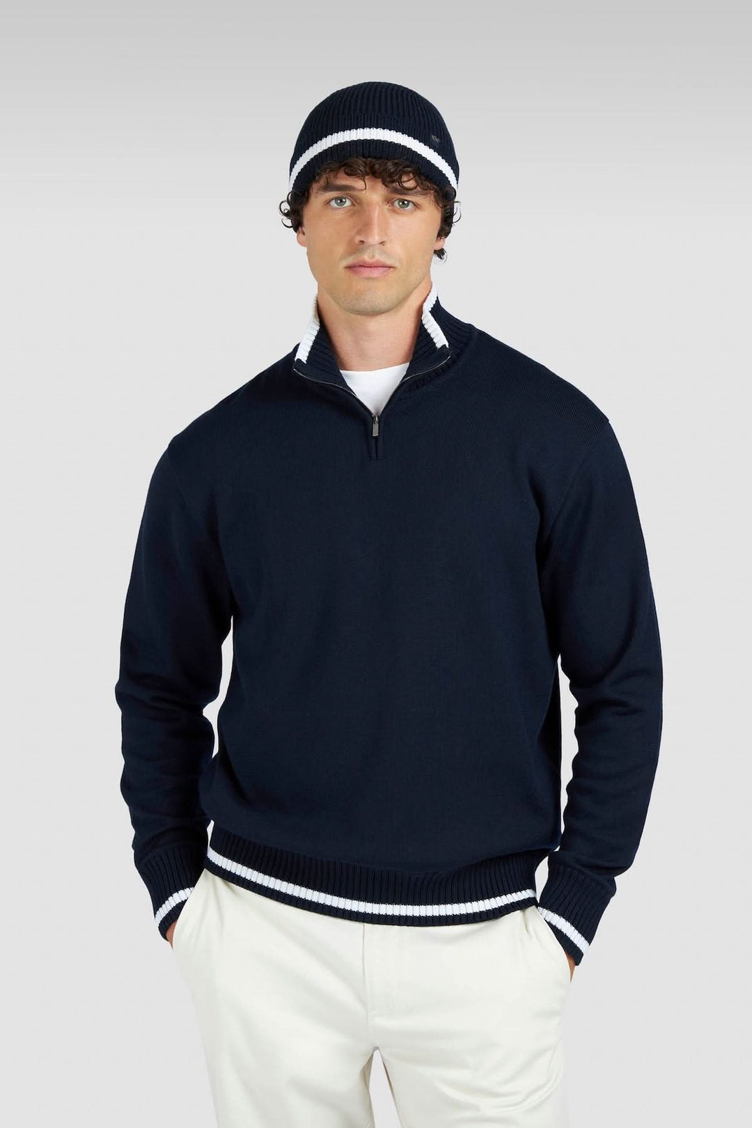 Homme portant un chandail à demi-fermeture éclair bleu marine et un bonnet assorti, style décontracté.