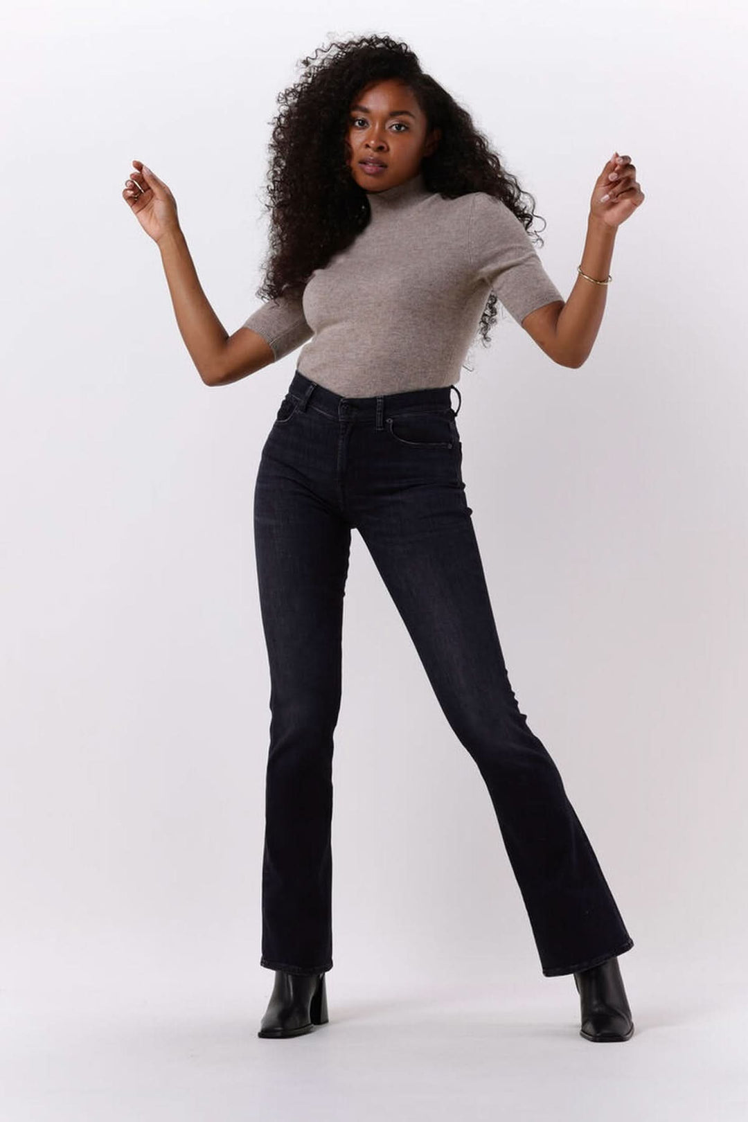 Femme portant Chandail col montant manches courtes — maille fine avec un jean foncé, style moderne et élégant.