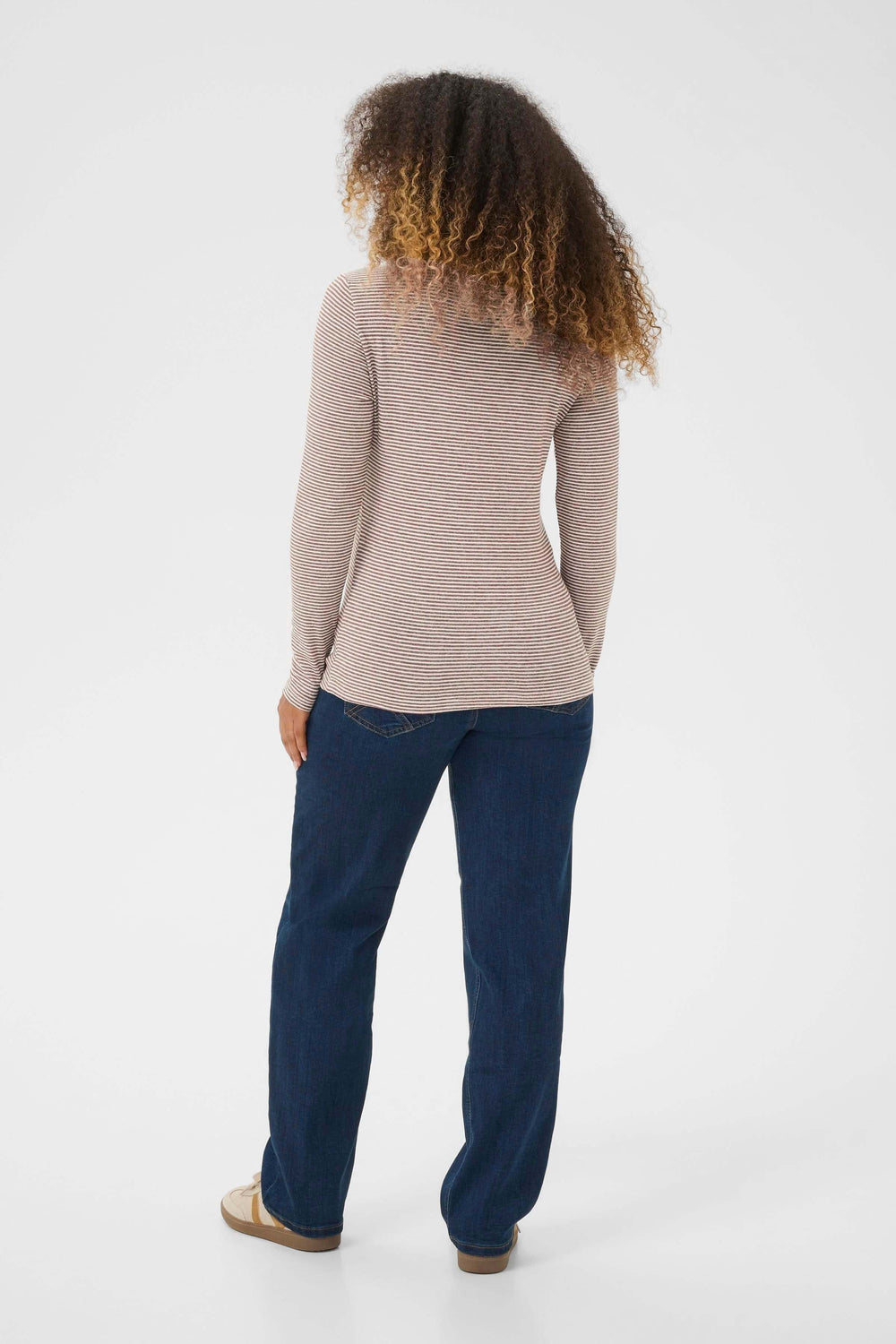 Person wearing Chandail Amma à col roulé rayé ajusté, showing its fitted style and fine stripes from the back view.