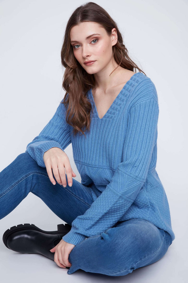 Tunique en tricot à manches longues bleue, avec encolure en V et détails texturés, portée avec un jean.