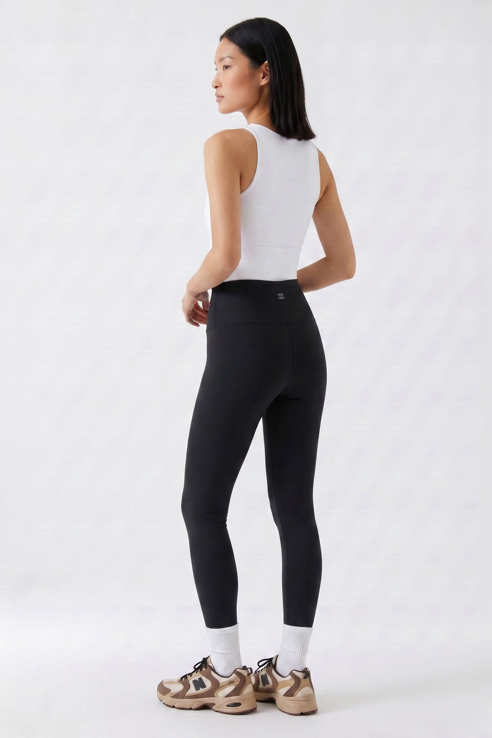 Vue de côté legging 7/8 taille haute femme noir avec logo discret Oui - Valérie Simon
