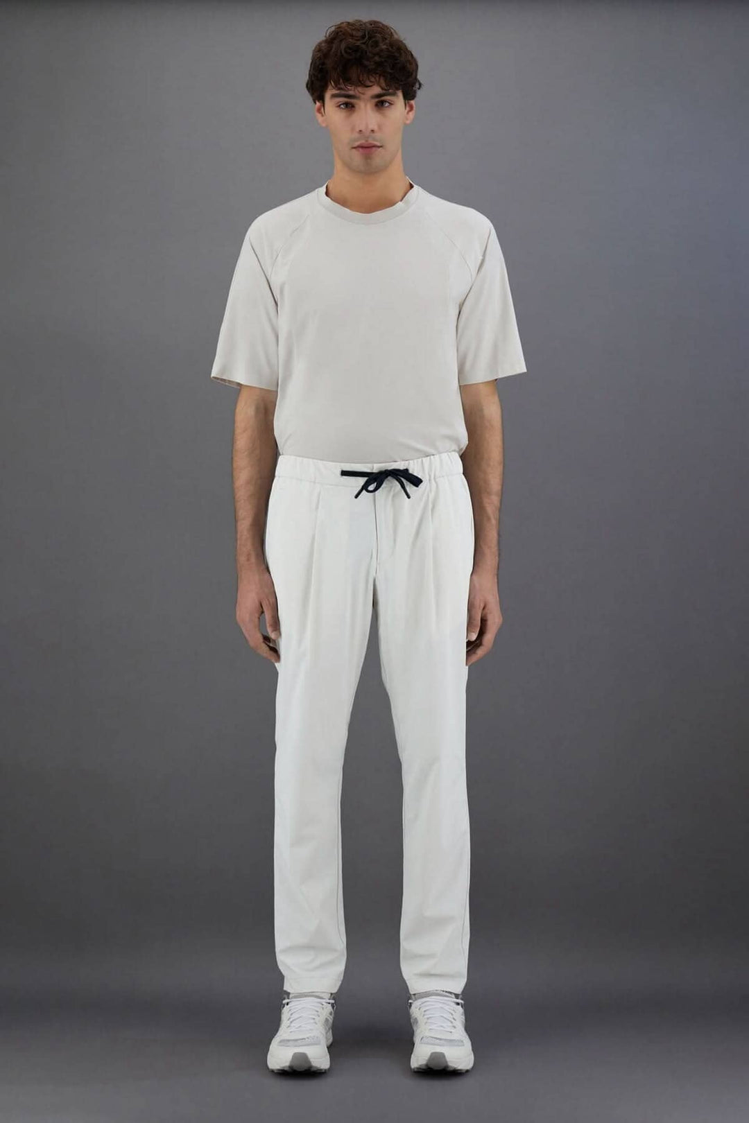 Homme portant un pantalon Laminar en nylon avec cordon de serrage, t-shirt beige, fond gris.