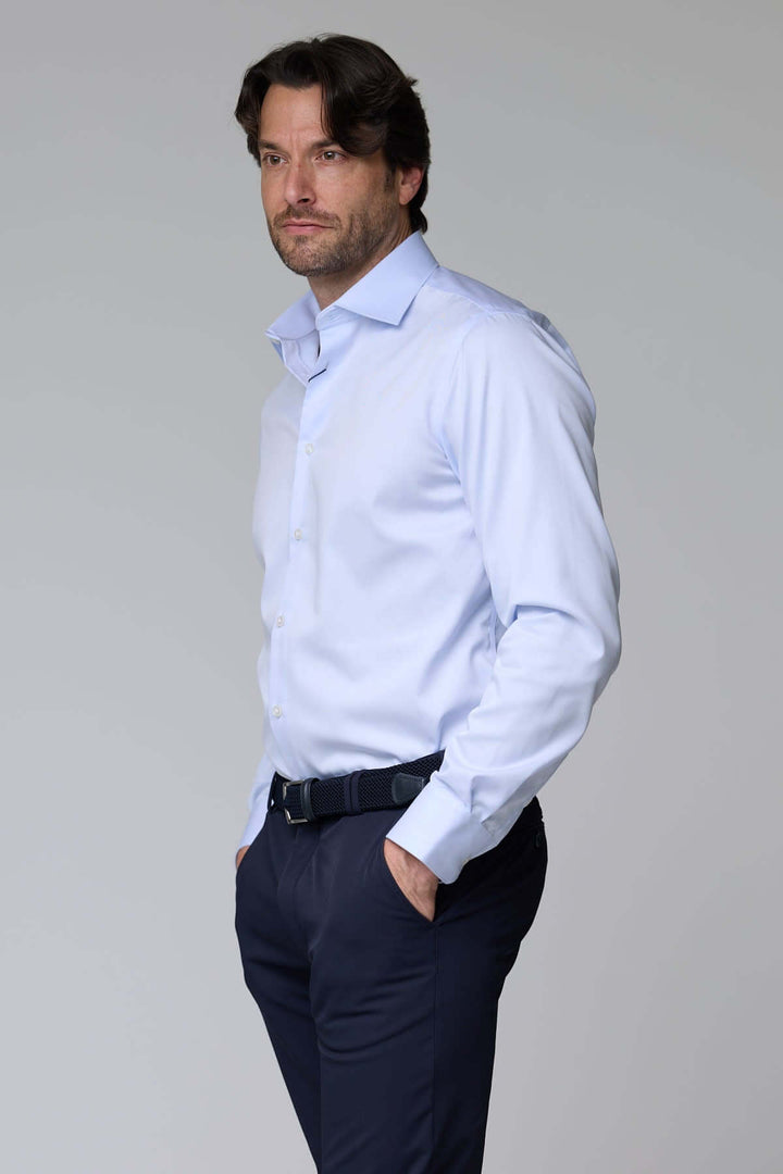 Homme portant une chemise habillée satinée à manches longues, offrant un look élégant et raffiné. Décris-moi le produit en français.