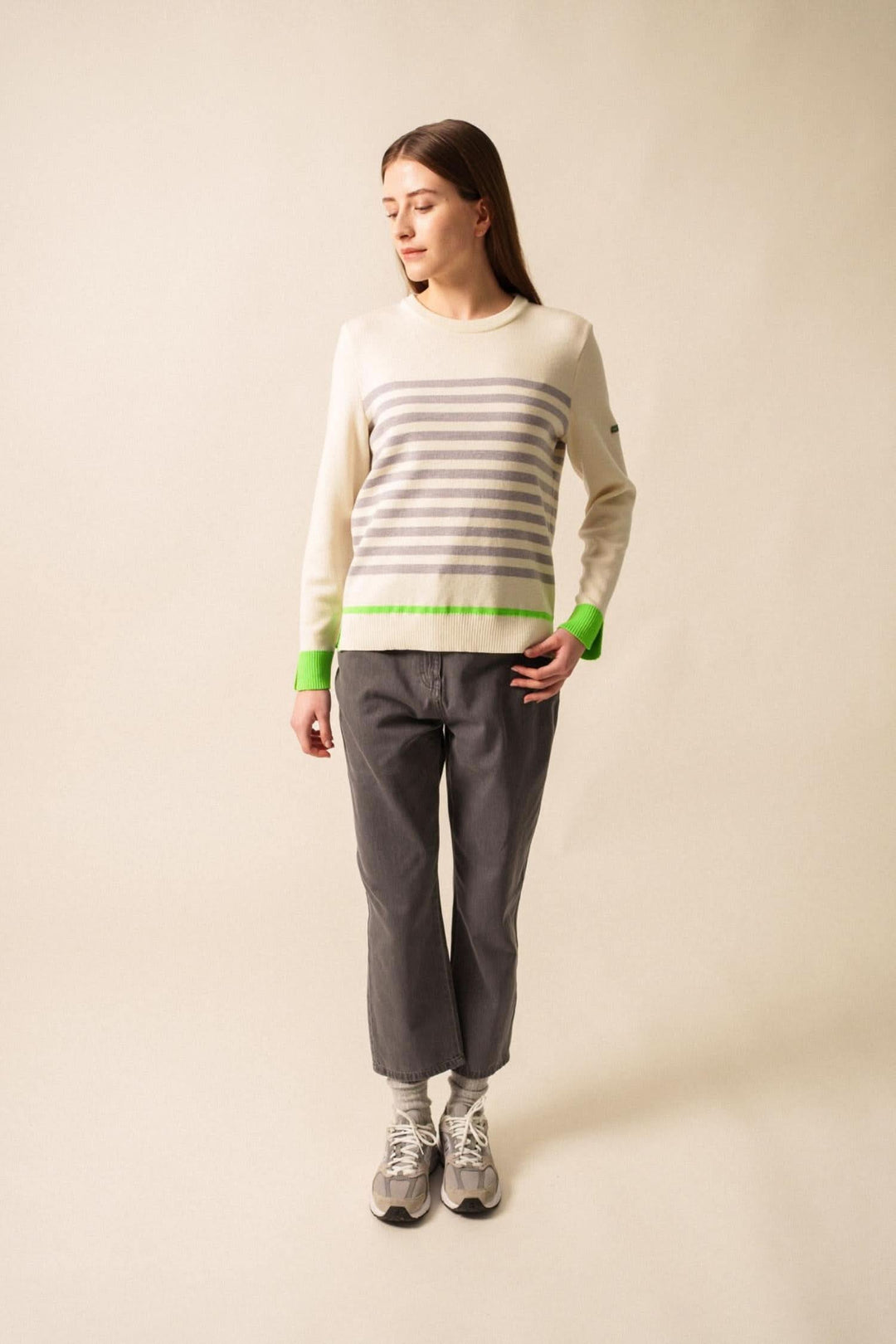 Chandail Evian à rayures contemporaines avec finitions fluo, porté avec un pantalon gris.