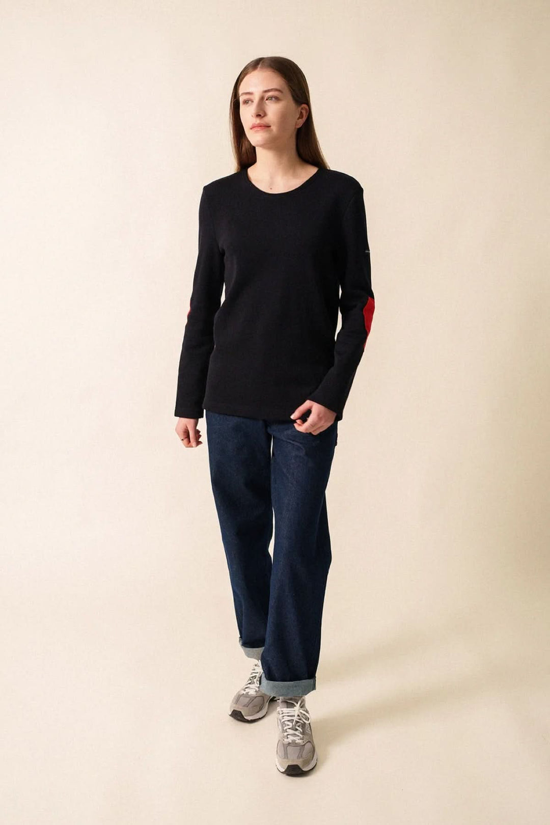 Chandail Vaujany en noir avec encolure ronde et coudes en cœur rouge. Look casual chic avec jean droit.