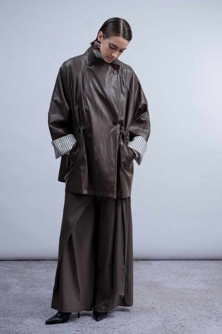 Front view of the Haako black faux leather coat for women with a belt and buttonhole - Valérie Simon