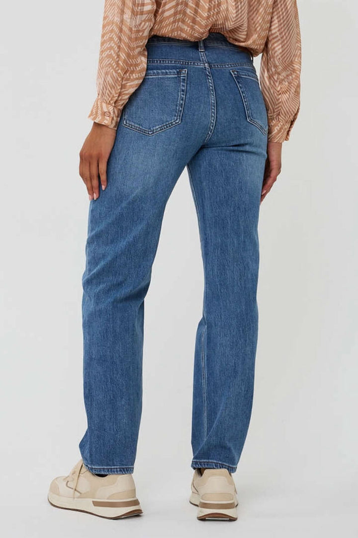 Jean à coupe droite en denim, vue arrière, porté avec une blouse et des baskets pour un look casual chic.