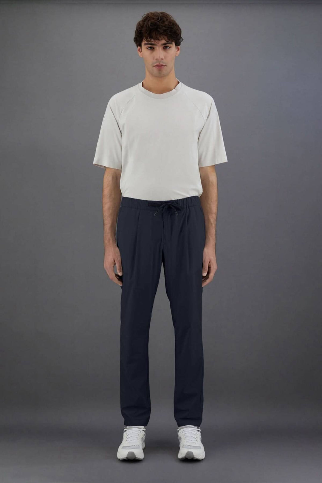 Homme portant un pantalon Laminar en nylon, style sportif et sophistiqué, avec t-shirt assorti.