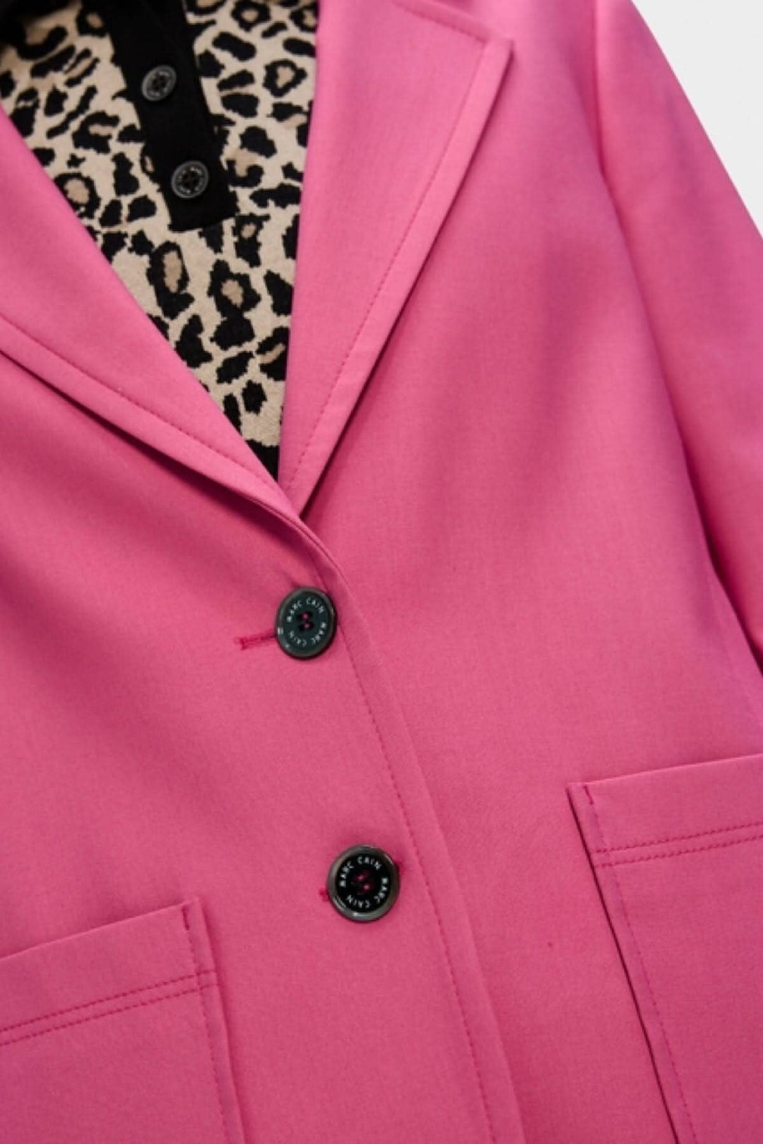 Veston à coupe étroite en rose avec revers classique et doublure en motif léopard.