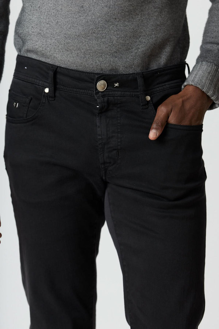 Jean 5 poches stretch coupe moderne noir pour homme avec tissu extensible et construction élégante, porté avec un pull gris.