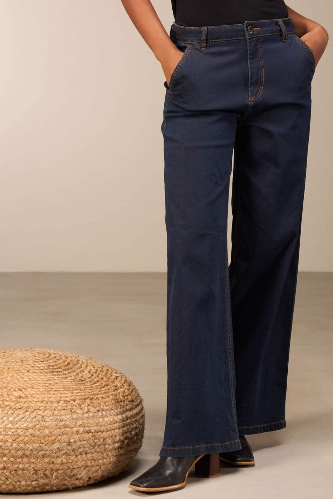 Jean coupe large bleu marine avec taille mi-haute, poches, porté avec un haut ajusté.