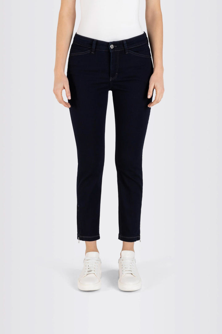 Jeans coupe ajustée longueur 7/8, tissu extensible, porté avec t-shirt et sneakers blancs.