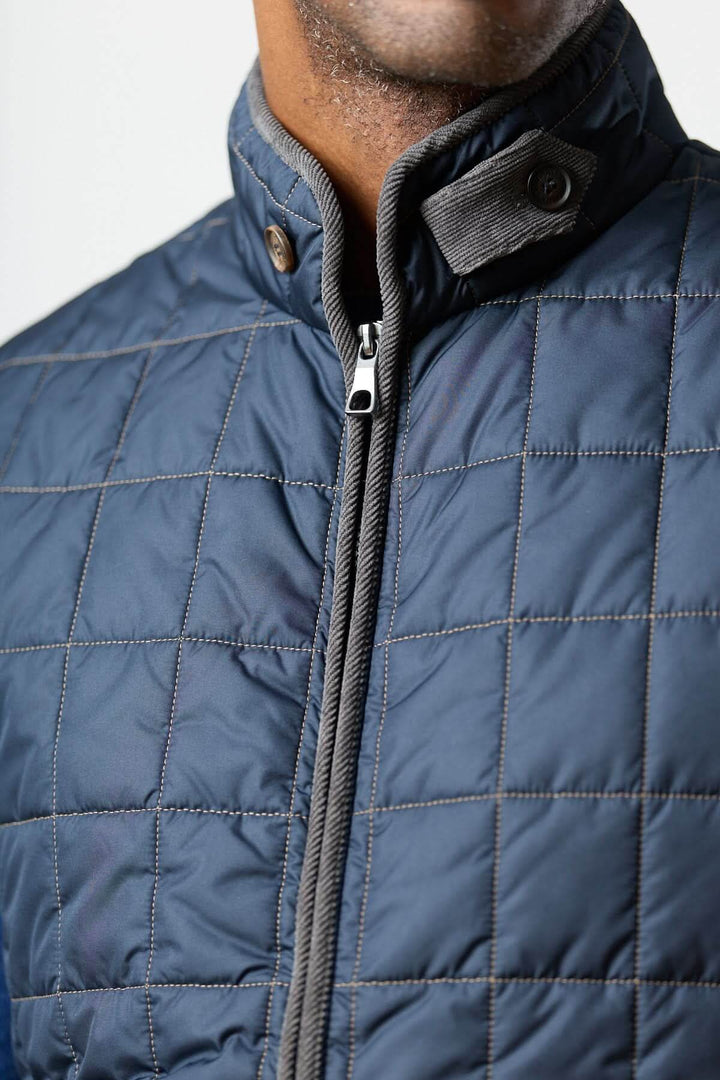 Veste sans manches matelassée avec détails en velours côtelé, montrant motif matelassé et boutons.