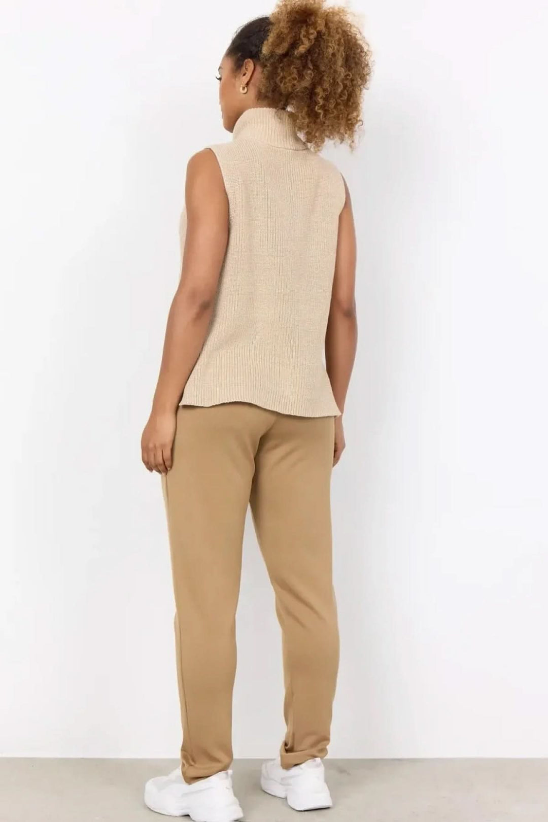 Vue arrière d'un débardeur en maille beige, associé à un pantalon décontracté beige, style moderne et sport-chic.