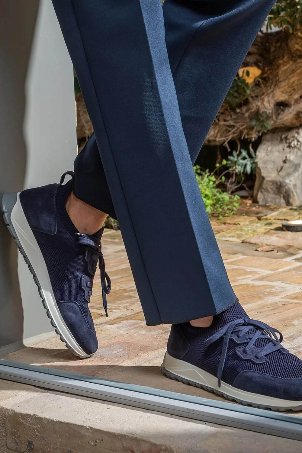 Sneaker homme cuir et tissu extensible avec semelle ultralégère montré avec un pantalon bleu pour un look moderne et raffiné.
