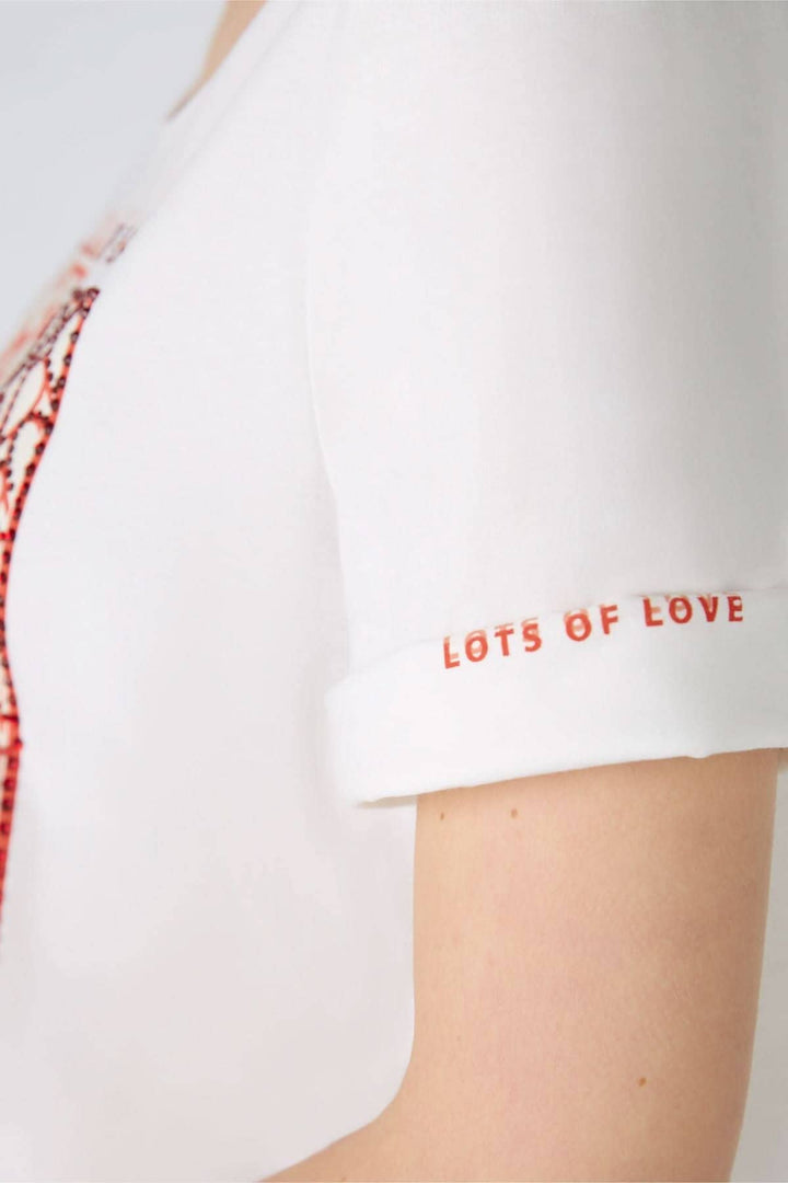 T-shirt blanc avec imprimé coloré sur le devant et texte 'LOTS OF LOVE' sur les manches courtes