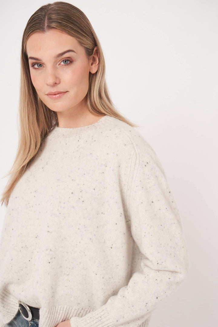 Femme portant un chandail moucheté en cachemire, doux et décontracté, col rond classique.